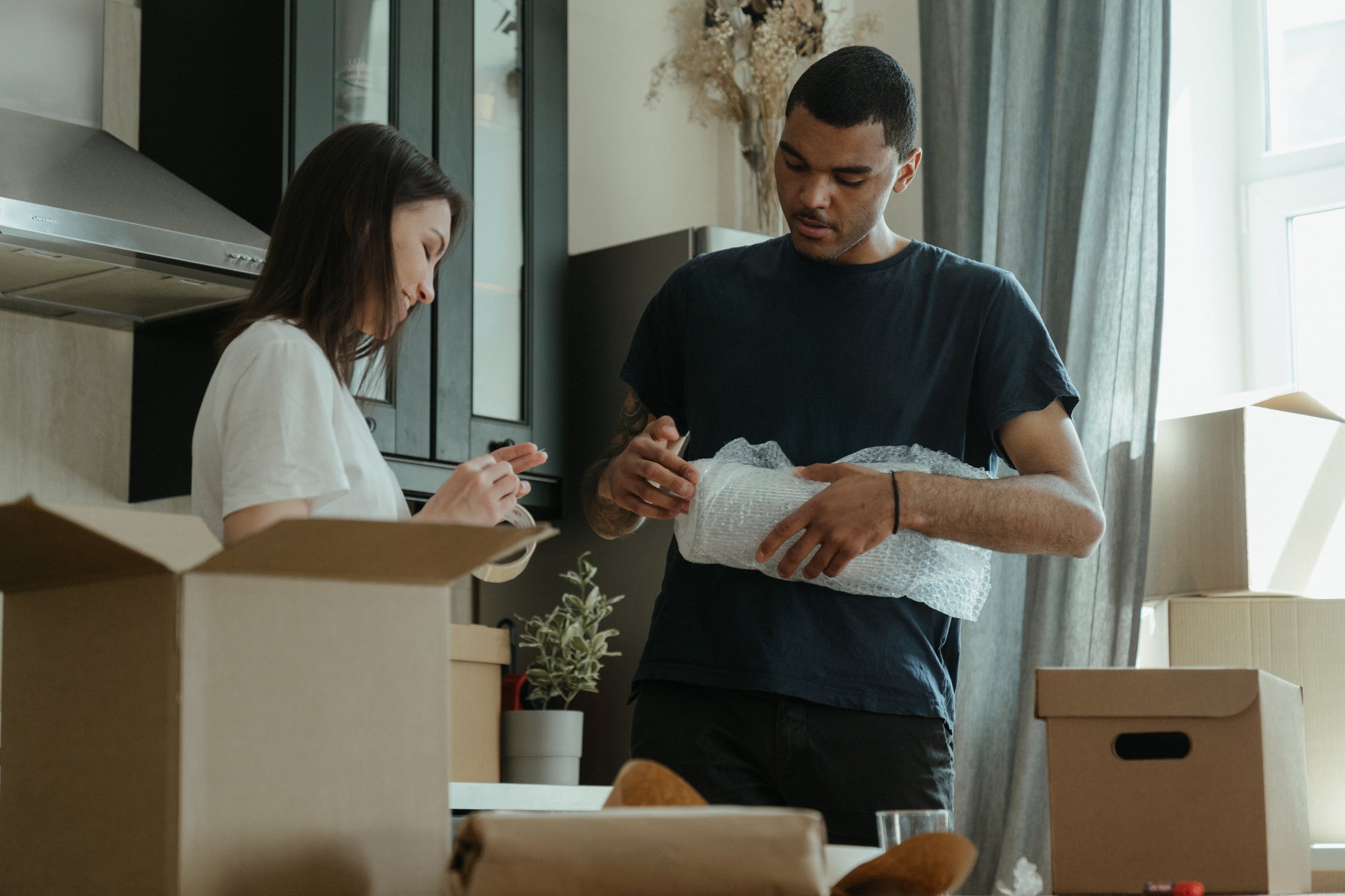 man and woman packing in kitchen